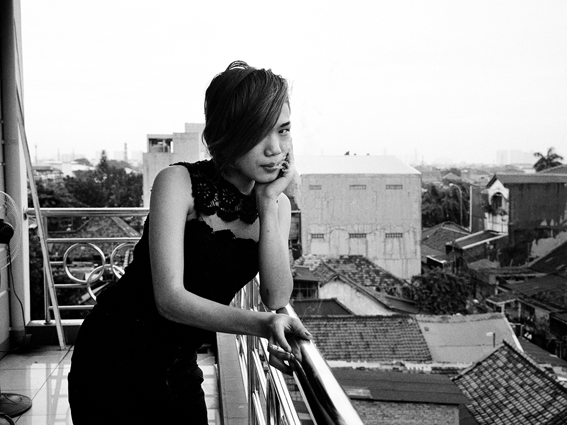 A young transgender having a smoke on the shared porch.